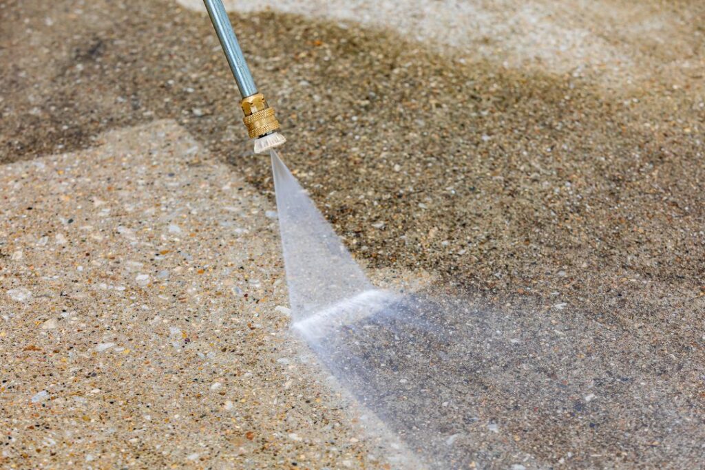 Pressure washing concrete to remove debris