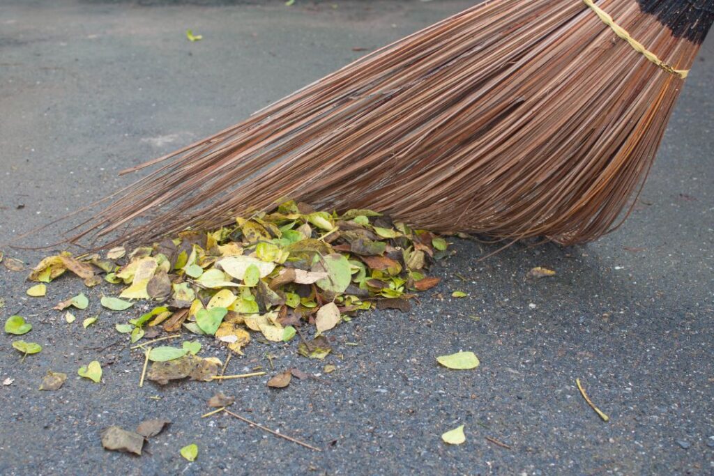 Sweeping away leaves and dirt on concrete